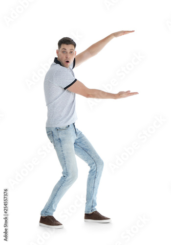 Emotional man in casual clothes holding something on white background