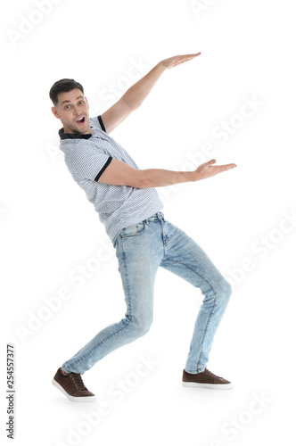 Emotional man in casual clothes holding something on white background