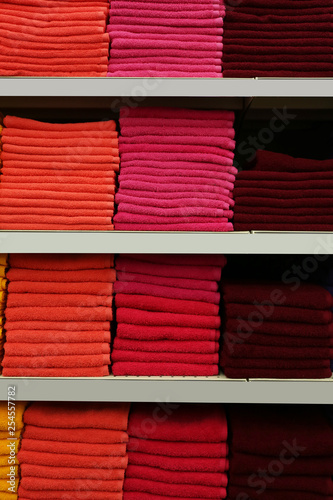 Stacks of colourful towels on store shelves