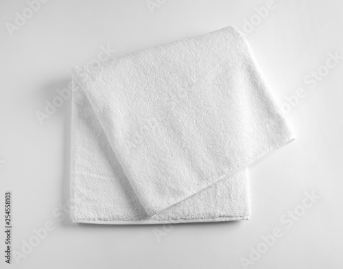 Fototapeta Folded soft terry towel on light background, top view