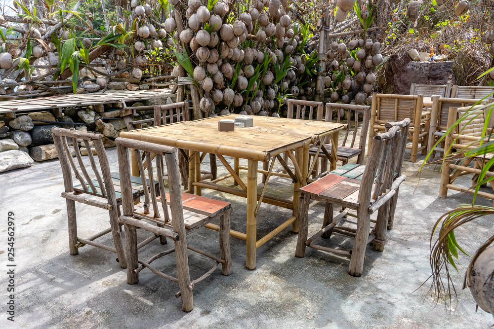 Wooden table and chairs in empty beach cafe next to sea. Island Koh Phangan, Thailand Wooden table and chairs in empty beach cafe next to sea. Island Koh Phangan, Thailand
