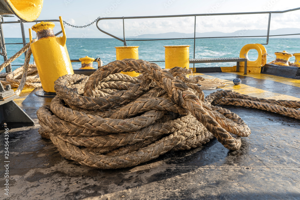 The deck of the ferry boat along with the a thick mooring rope and blue sea  water wave, Thailand. Close up Stock Photo