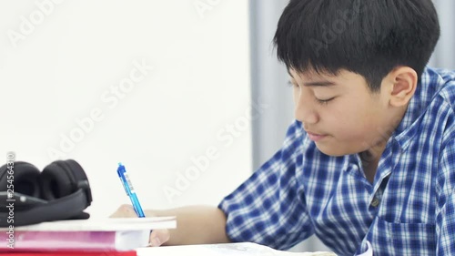 Asian cute boy doing your homework with smile face at home ,4K Dolly shot.