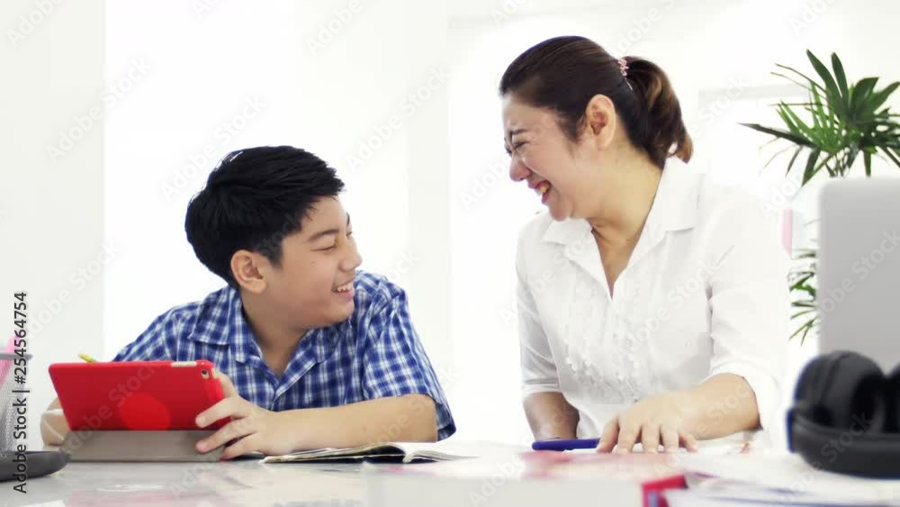 Mother and son play and watching smartphone ,Dolly shot of happy asian family with smily face at home . Mother and son play and watching smartphone ,Dolly shot of happy asian family with smily face at home .