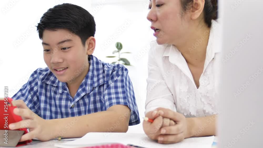 Mother and son play and watching smartphone ,Dolly shot of happy asian family with smily face at home . Mother and son play and watching smartphone ,Dolly shot of happy asian family with smily face at home .