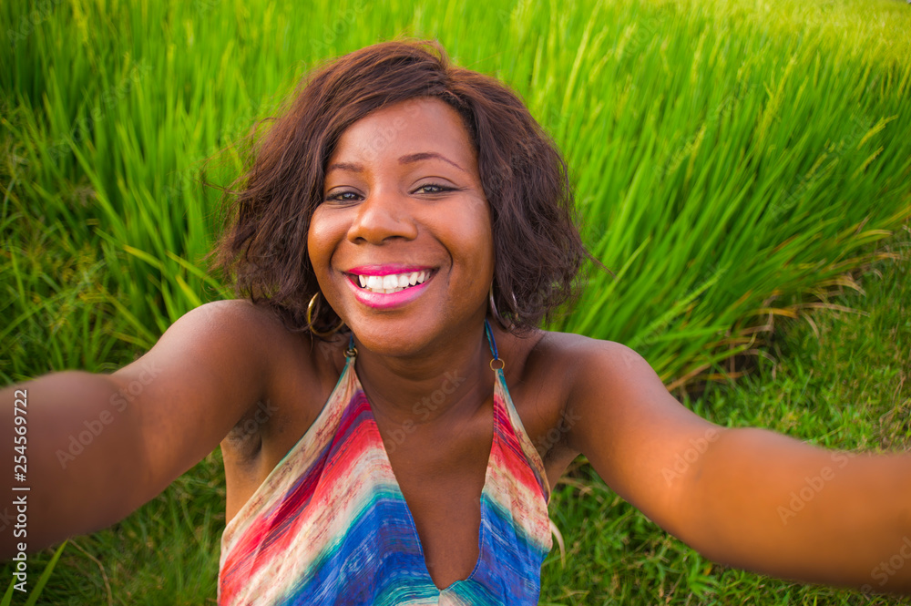 happy and attractive black afro American woman in beautiful dress taking selfie portrait with internet mobile phone enjoying holidays travel in Asia smiling cheerful at rice field happy and attractive black afro American woman in beautiful dress taking selfie portrait with internet mobile phone enjoying holidays travel in Asia smiling cheerful at rice field