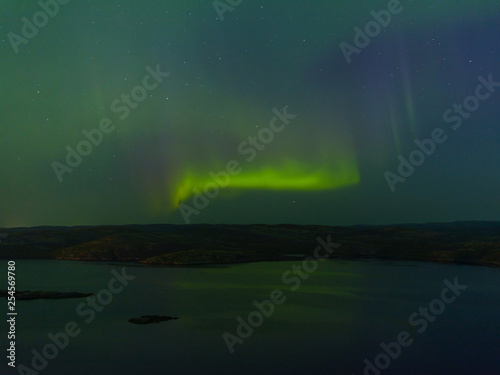 Green northern lights over the water, reflection, aurora.