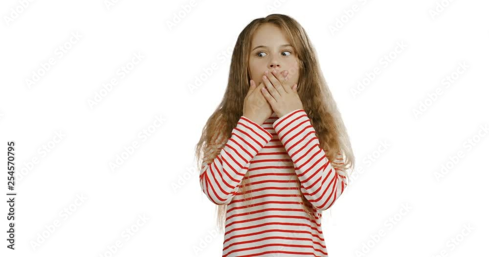 Portrait of the blonde teenager girl with long hair in the striped blouse closing her mouth with hands and doing oops grimacing or very surprised face. White wall background. Portrait of the blonde teenager girl with long hair in the striped blouse closing her mouth with hands and doing oops grimacing or very surprised face. White wall background.