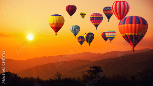 Blur of image hot air balloon above high mountain at sunset