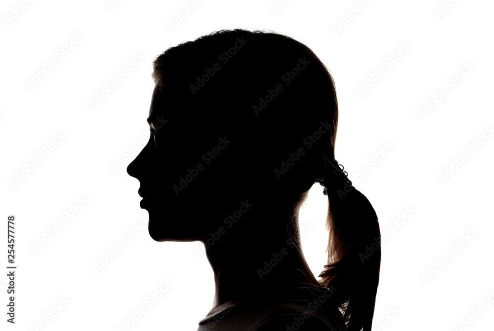 Dark silhouette profile of a young girl on a white background, the concept of anonymity Dark silhouette profile of a young girl on a white background, the concept of anonymity