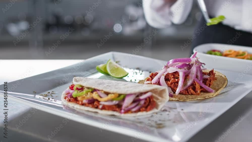Cheff adding habanero peppers to cochinita pibil tacos. Cheff adding habanero peppers to cochinita pibil tacos.