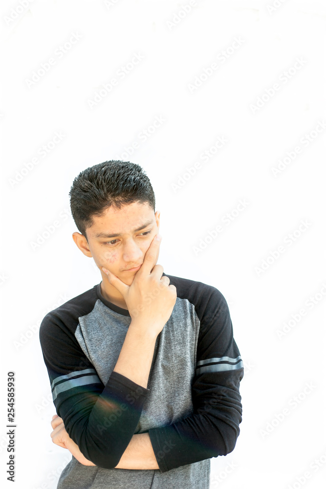 Portrait shot of a Caucasian teenager wearing a black colored full sleeves t-shirt and expressing doubtfulness on his face.Isolated on white. Portrait shot of a Caucasian teenager wearing a black colored full sleeves t-shirt and expressing doubtfulness on his face.Isolated on white.