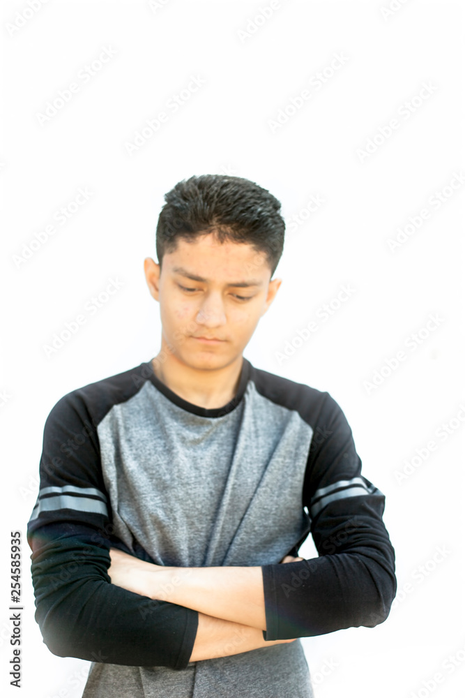 Portrait shot of a Caucasian teenager wearing a black colored full sleeves t-shirt and expressing doubtfulness on his face.Isolated on white. Portrait shot of a Caucasian teenager wearing a black colored full sleeves t-shirt and expressing doubtfulness on his face.Isolated on white.