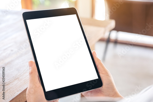 Mockup image of a woman holding black tablet pc with blank white screen