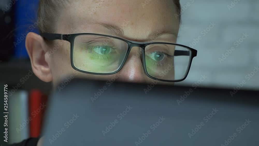 attractive business woman working on laptop in office. woman with glasses looks at computer monitor. attractive business woman working on laptop in office. woman with glasses looks at computer monitor.