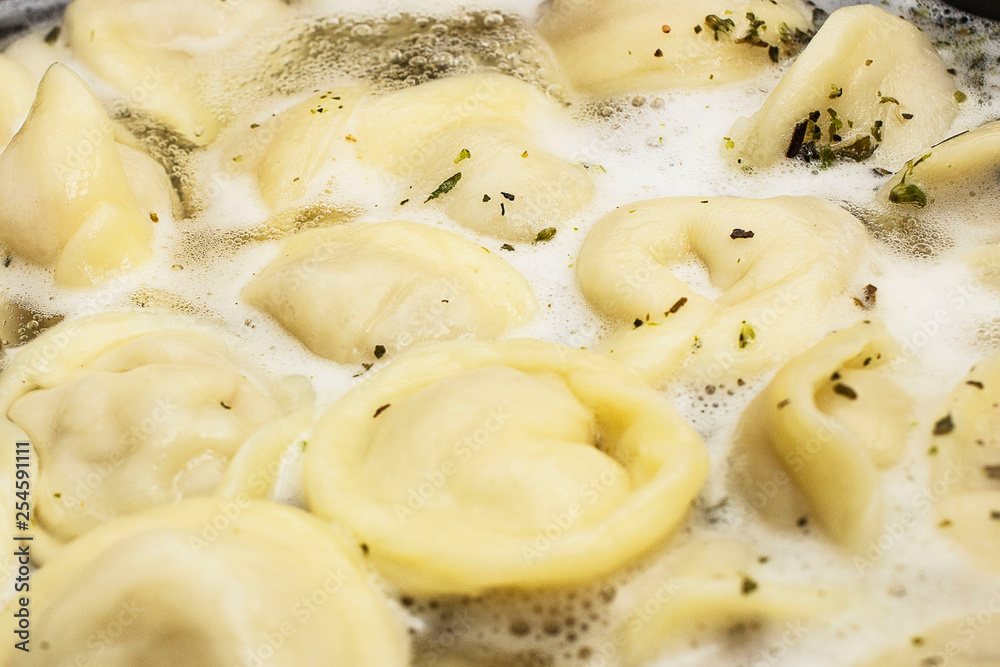 meat dumplings are boiled in a pot of boiling water