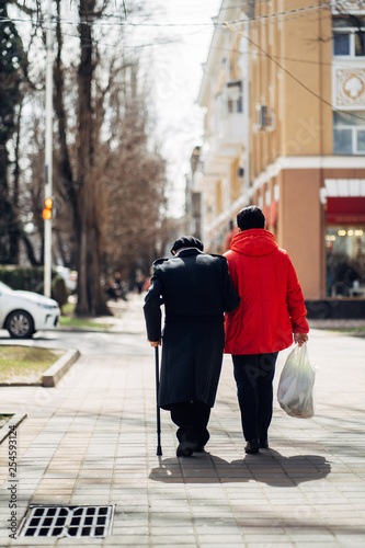 Back view of elder couple walking in the street.