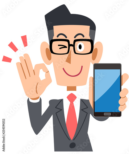 スマートフォンを持ってOKのサインを出す眼鏡をかけたビジネスマン