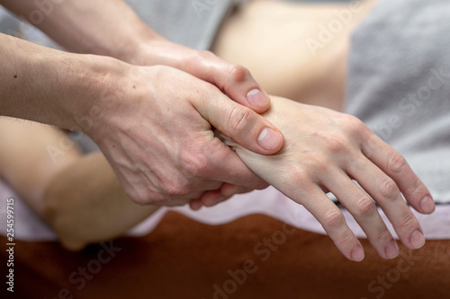Beautiful young woman is receiving a hand massage at a massage salon