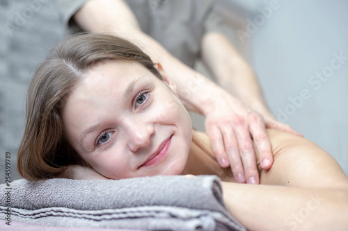 Beautiful young woman is receiving a massage at a massage salon