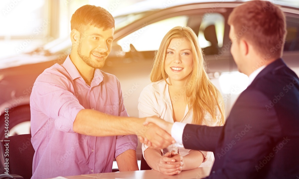 Fototapeta premium Happy family with car dealer in auto show or salon buy a car
