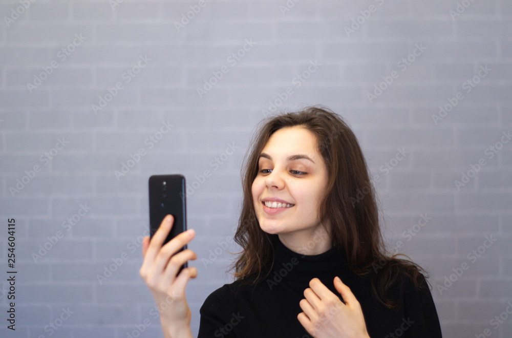 Young smiling woman through the camera looks at her teeth Young smiling woman through the camera looks at her teeth