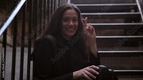 Medium shot of an attractive woman crossing her fingers for luck on both hands and clenching her eyes tightly 