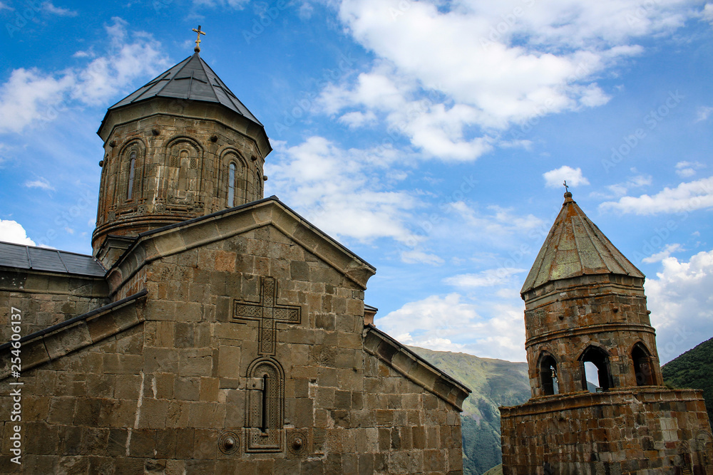 Gergeti Trinity Church in Georgia, Stepantsminda, Kazbegi. Orthodoxy, Christianity, religion, cross. Blue sky. 