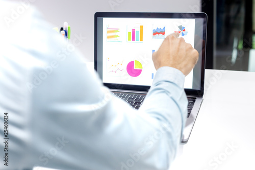 Businessman workspace laptop with coffee cup ,computer screen graphics and charts