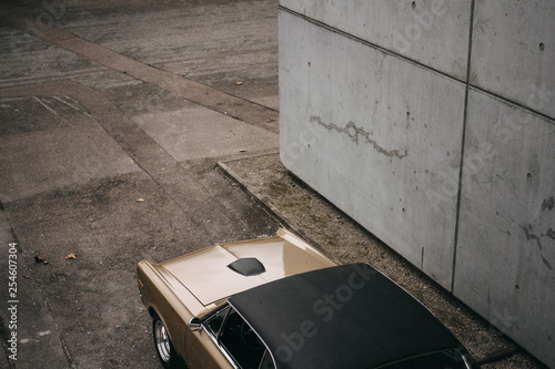 american classic muscle car standing in a gateway next to a grey wall
