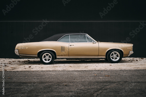 Canvas Print american classic muscle car standing in front of a black wall