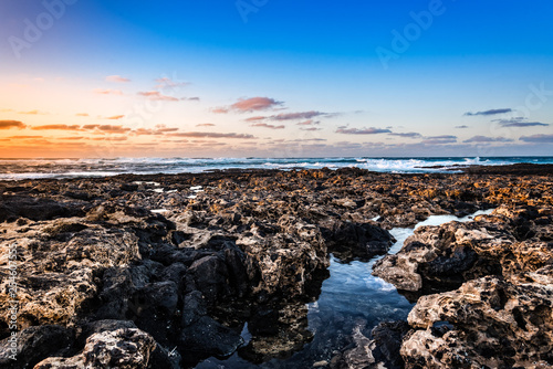 Scenic view of rocky beach at sunset