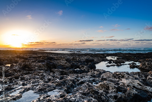 Scenic view of rocky beach at sunset