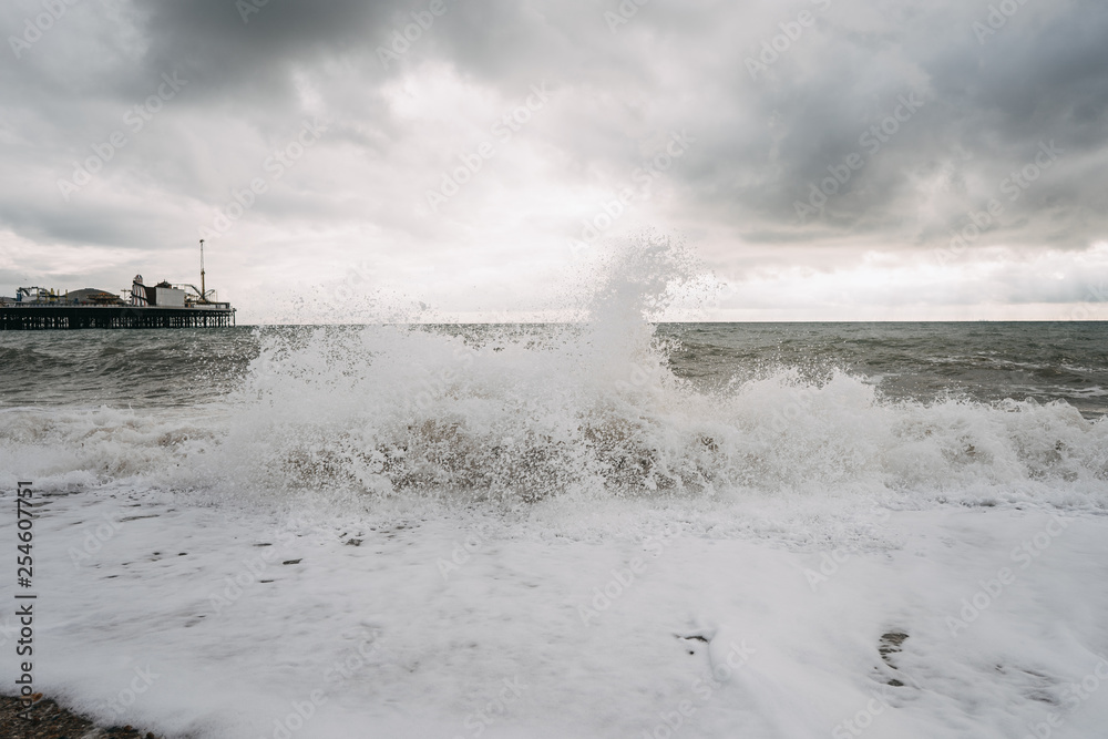 waves with dramatic sky and brighton pier in the background