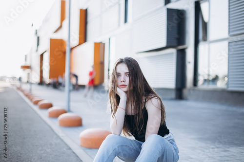 Cute cheerful portrait of young teenage girl outdoors in the street . Emotions, portrait, beauty concept