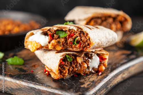 Mexican burrito with beef, beans and sour cream photo