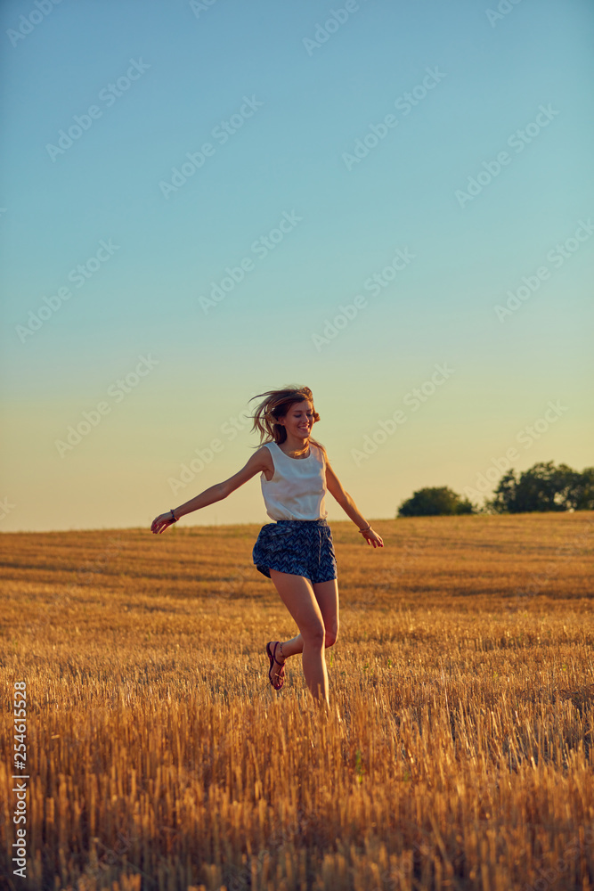 Cute young woman jumping in a wheat field. Cute young woman jumping in a wheat field.