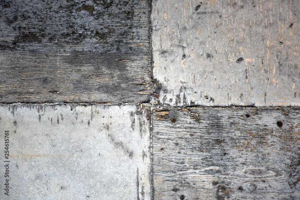 A fragment of a concrete wall with traces of plywood formwork and wood texture