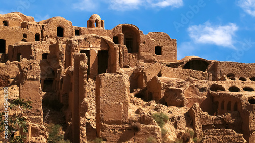 Ancient red clay village Kharanagh against blue sky. Persia. Iran. Sight of Yazd. photo