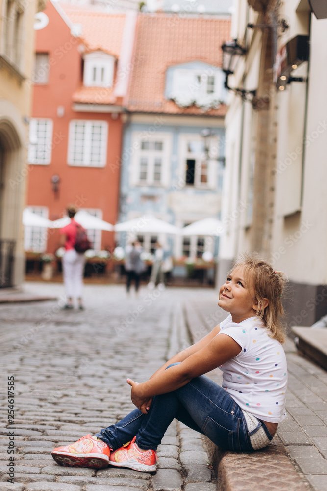 Little adorable cute girl in the street walking. Urban, vacation, travel, childhood concept