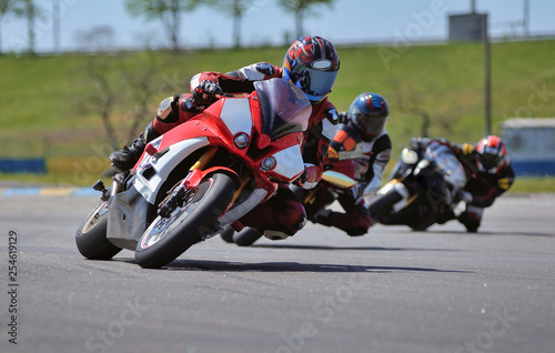 Road racing motorcykel in high speed into a curve, panning shot photo