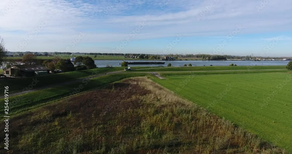Aerial view of summer field around of river with ship sailing