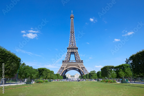 Eiffel Tower in Paris and empty green field of Mars meadow in a sunny summer day  clear blue sky