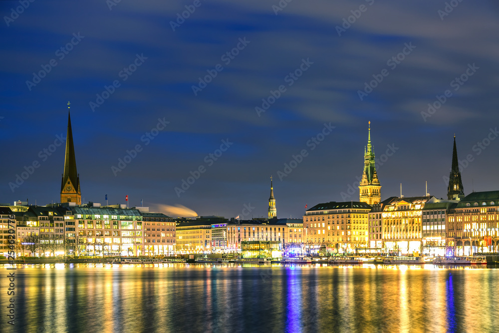 Binnenalster Lake with illuminated city center in Hamburg, Germany during twilight sunset.