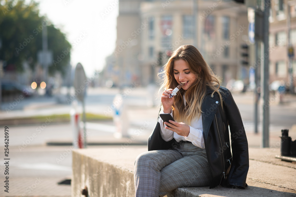 Woman sitting outside having a bite of chocolate bar