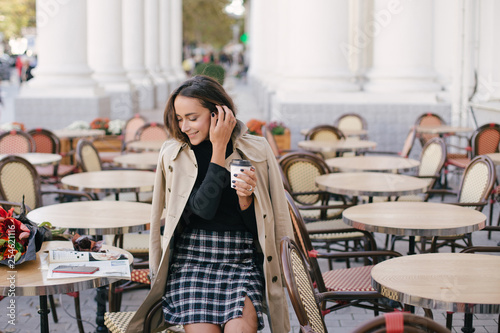 Young beautiful woman drinking coffee in a street cafe photo