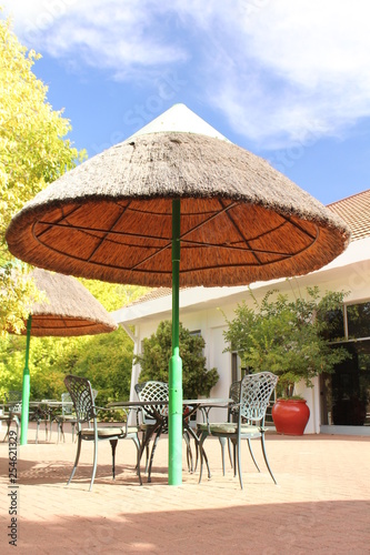 Tables with chairs under sun umbrellas - place to sit and relax in a holiday resort