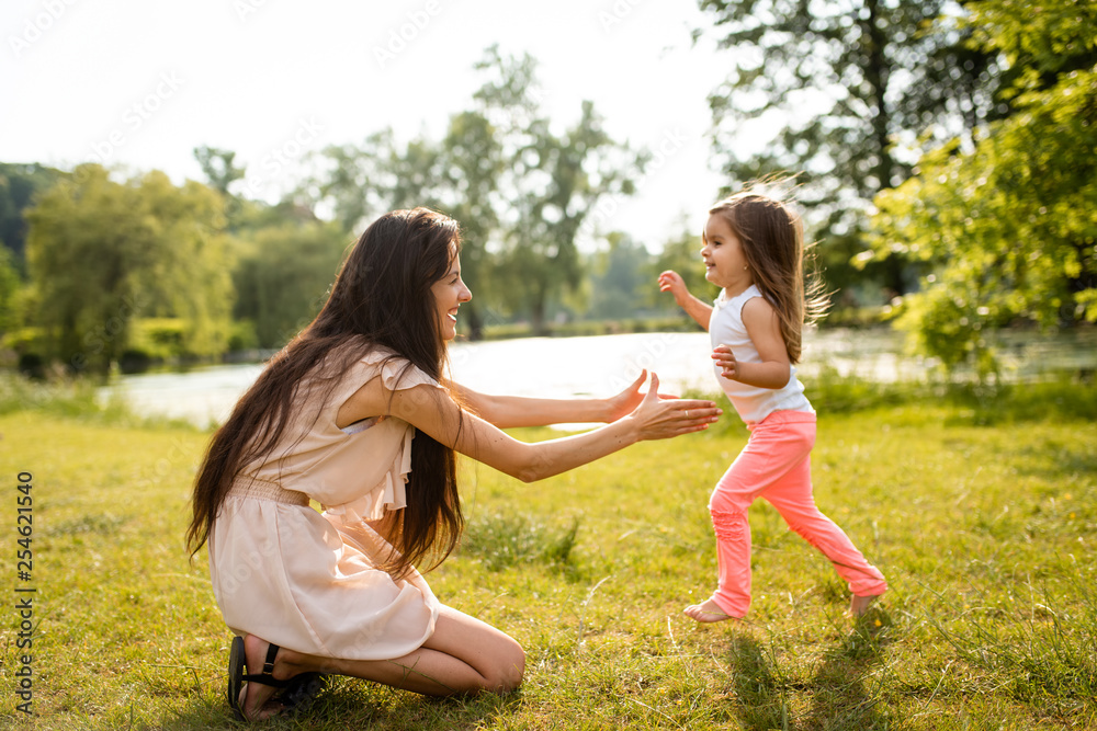 Little girl in park running towards her mother Little girl in park running towards her mother