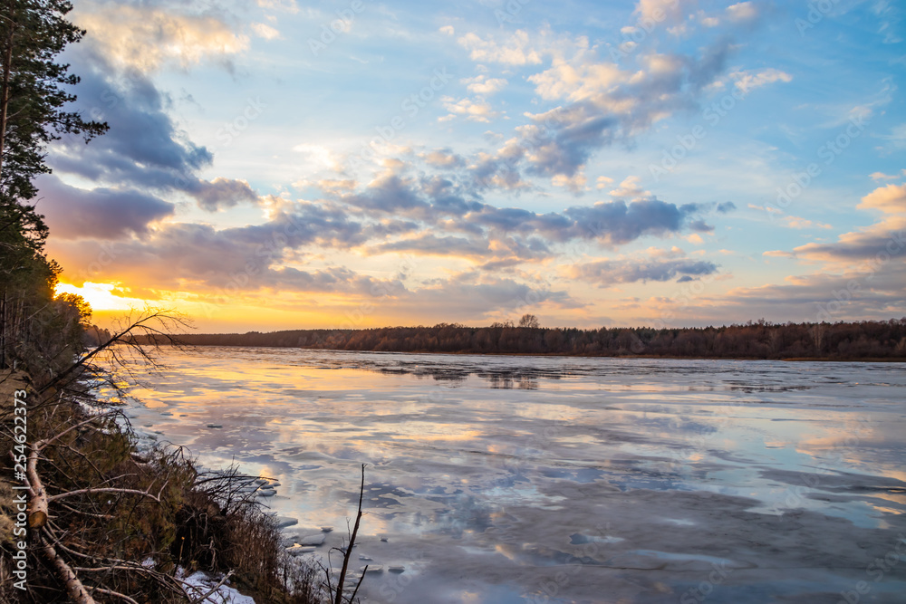 The descent of ice in the spring on the river in March is a natural phenomenon against the sky and clouds in the evening. The descent of ice in the spring on the river in March is a natural phenomenon against the sky and clouds in the evening.