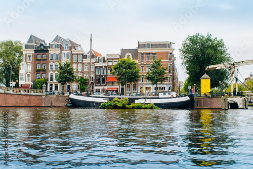 Amsterdam, Netherlands September 5, 2017: Reflection of trees and houses in still water of Amstel river, Amsterdam, Netherlands.